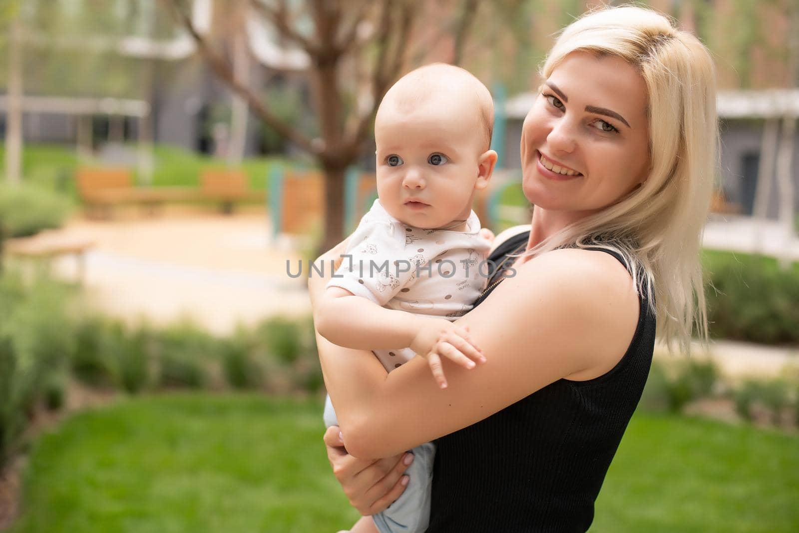 Portrait of beautiful happy smiling mother with baby outdoor.