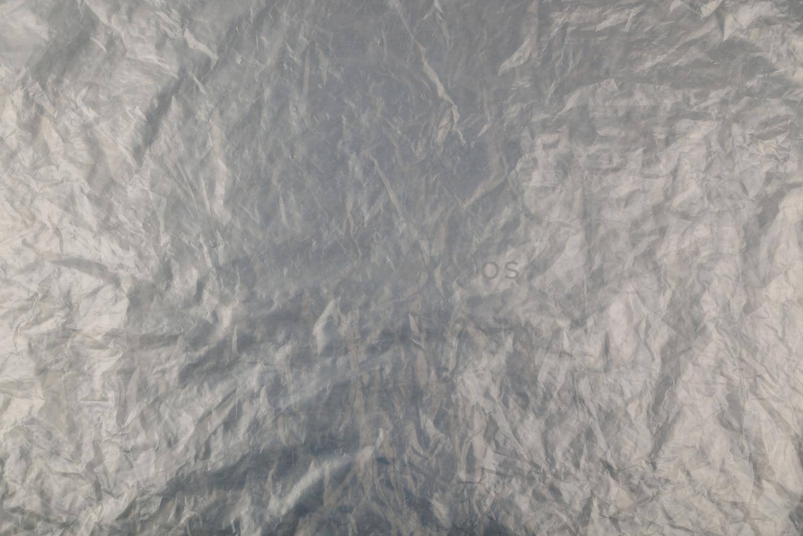 full frame background of flat crumpled semi-transparent polyethylene film.