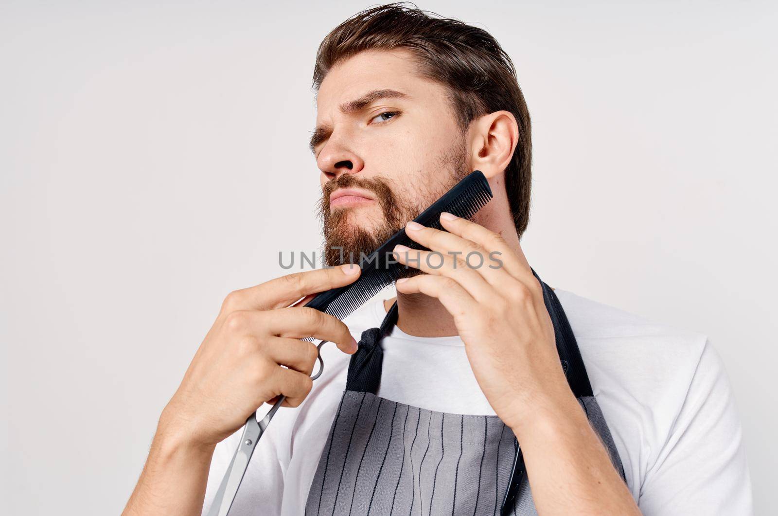 barbershop model man gray apron beard hairstyle. High quality photo
