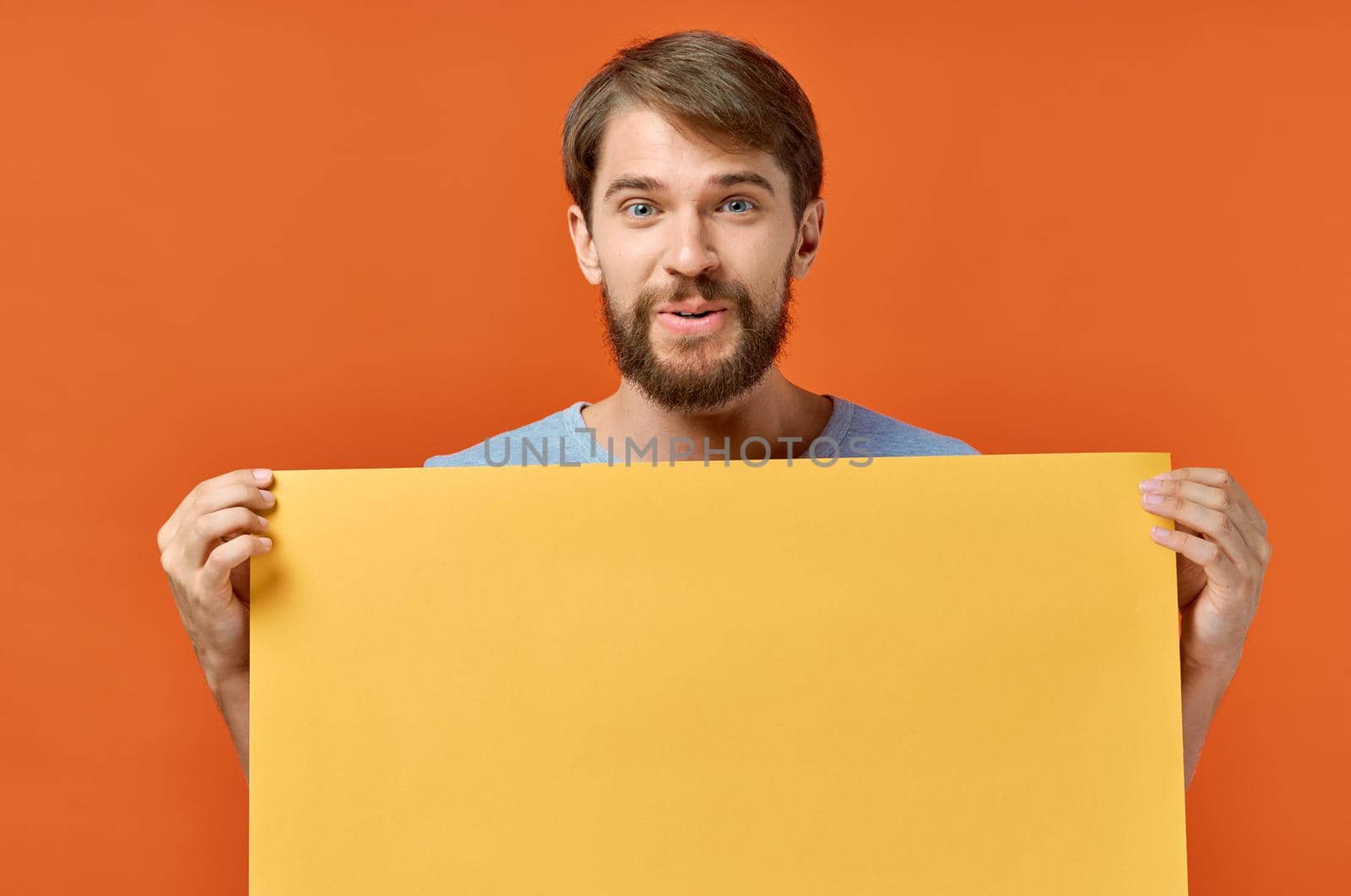 emotional man holding a yellow banner design studio lifestyle. High quality photo