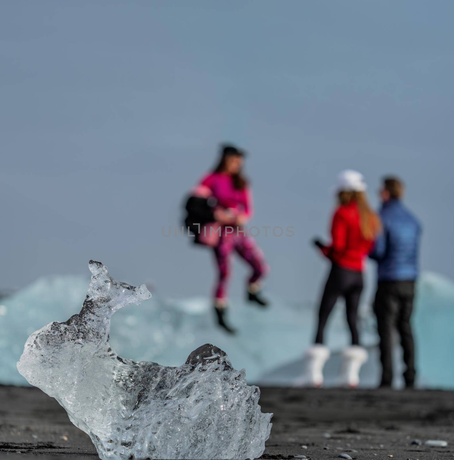Blurred tourists in the background and iceberg with rabbit shape in focus