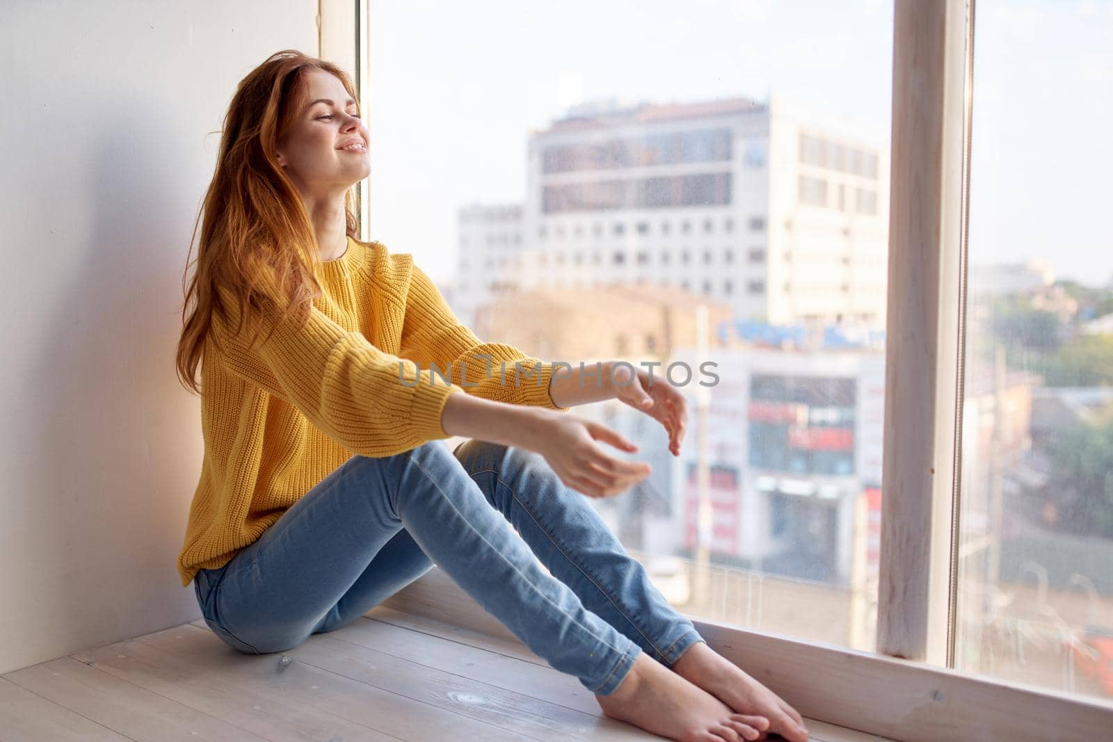 red-haired woman lies on the windowsill Lifestyle. High quality photo