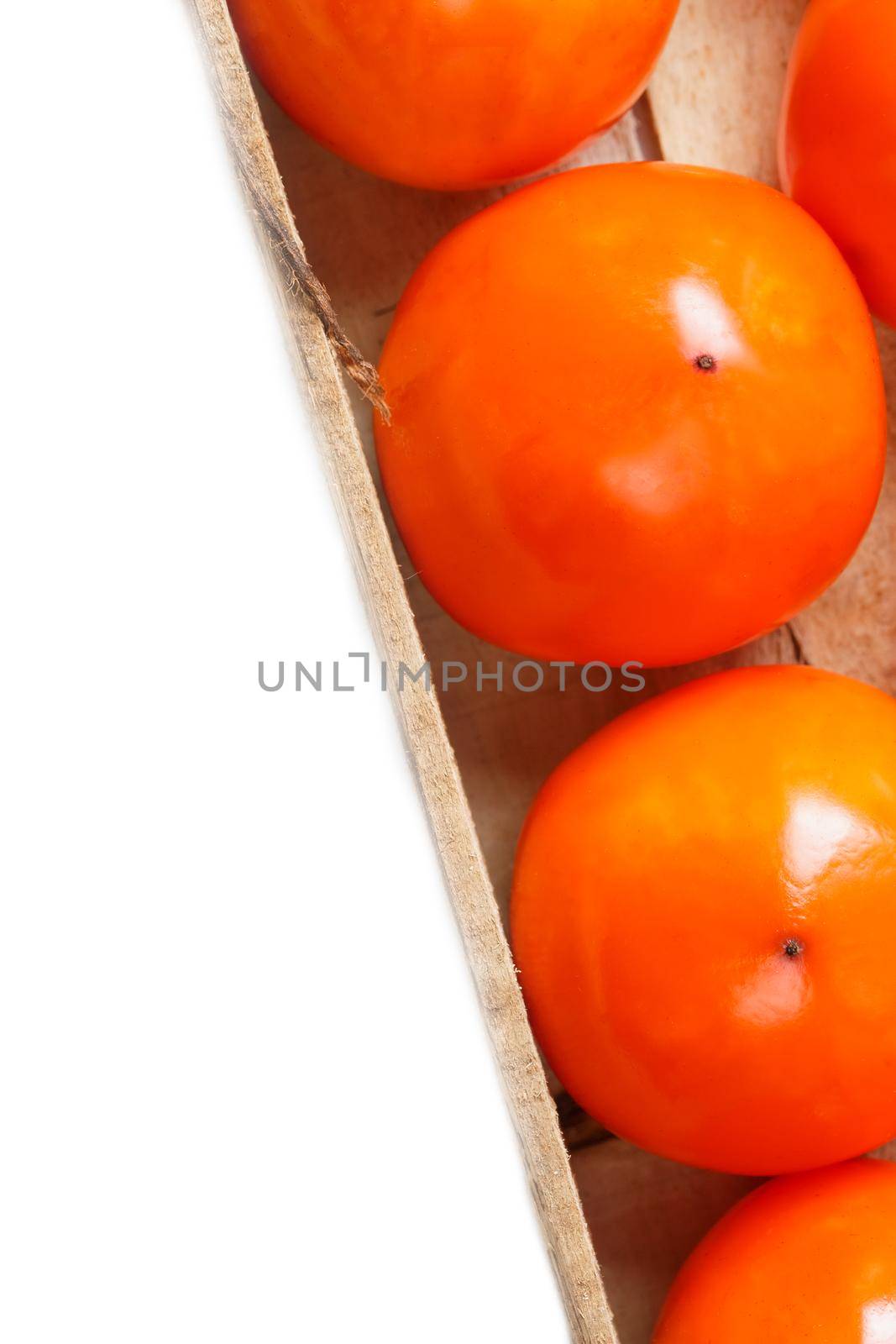 Fresh ripe persimmons in market. Persimmons background. Repeating rows of juicy, ripe persimmon in a box. Close-up, macro