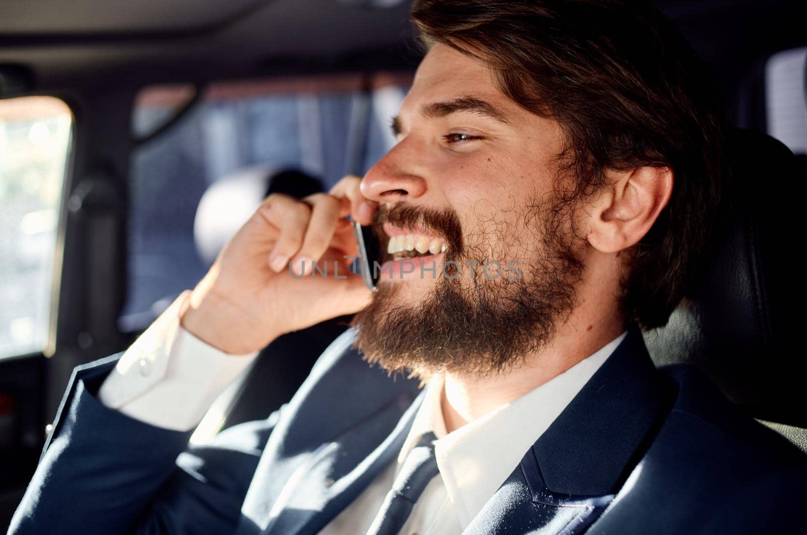 business man with a beard talking on the phone in a car trip. High quality photo