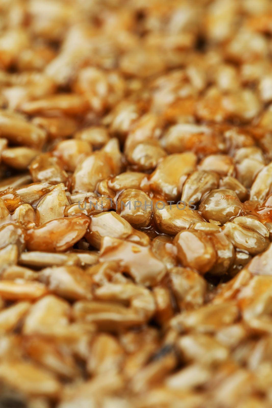 Kozinaki from golden, roasted sunflower seeds as a background, texture. Macro shooting, close-up. Place for text