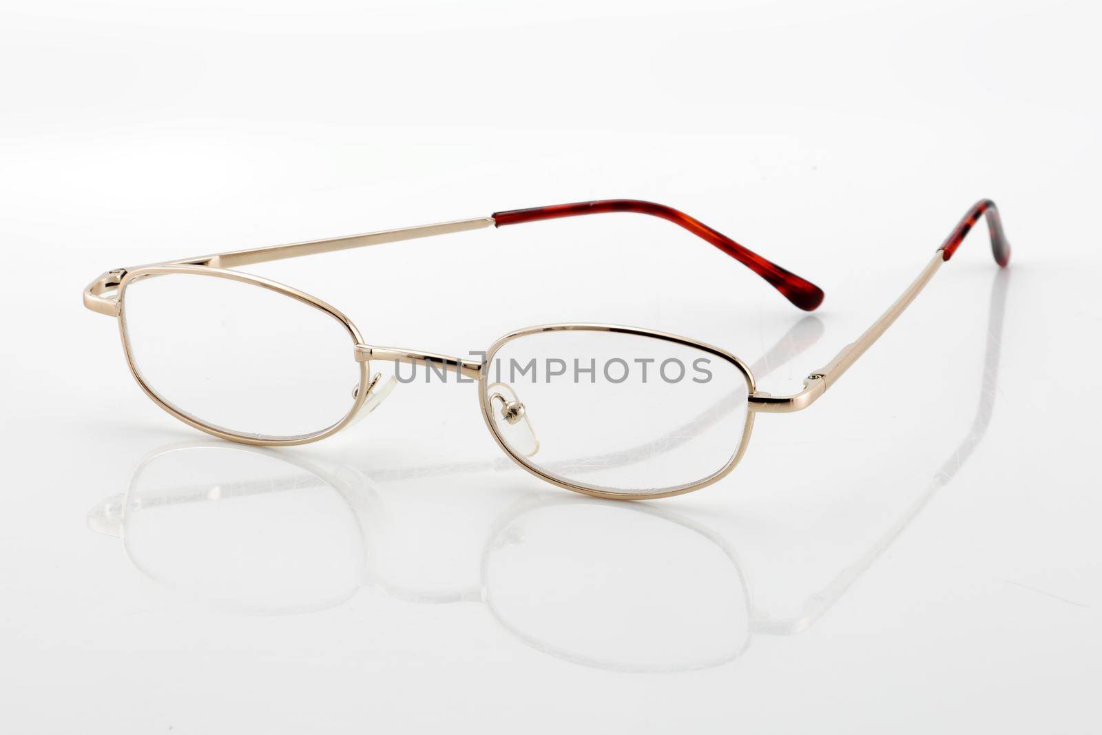 A pair of reading glasses on white background with shadow and differential focus