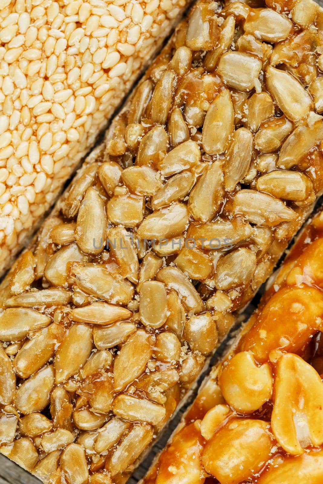 Assorted kozinaki, sweets from sunflower seeds, sesame and peanuts filled with brilliant glaze. Macro close up