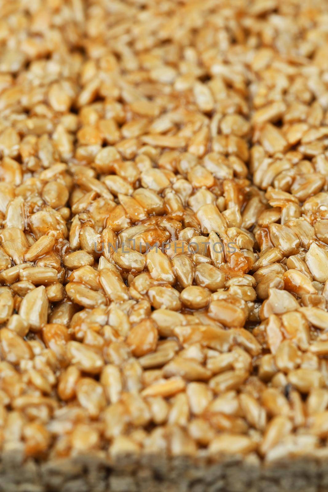 Kozinaki from golden, roasted sunflower seeds as a background, texture. Macro shooting, close-up. Place for text