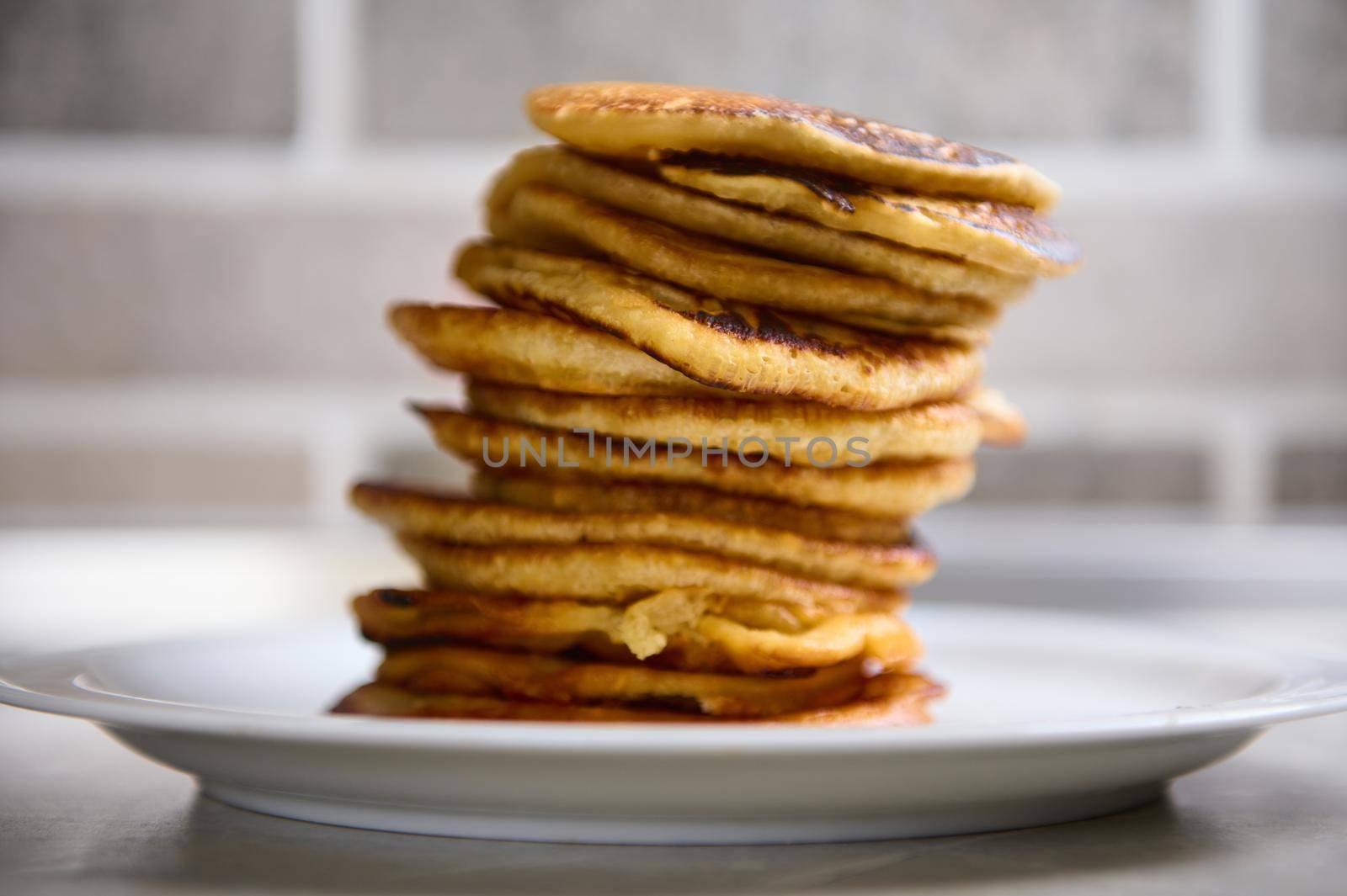 Close-up. A stack of freshly baked pancakes on a white ceramic plate. Shrove Tuesday concept by artgf