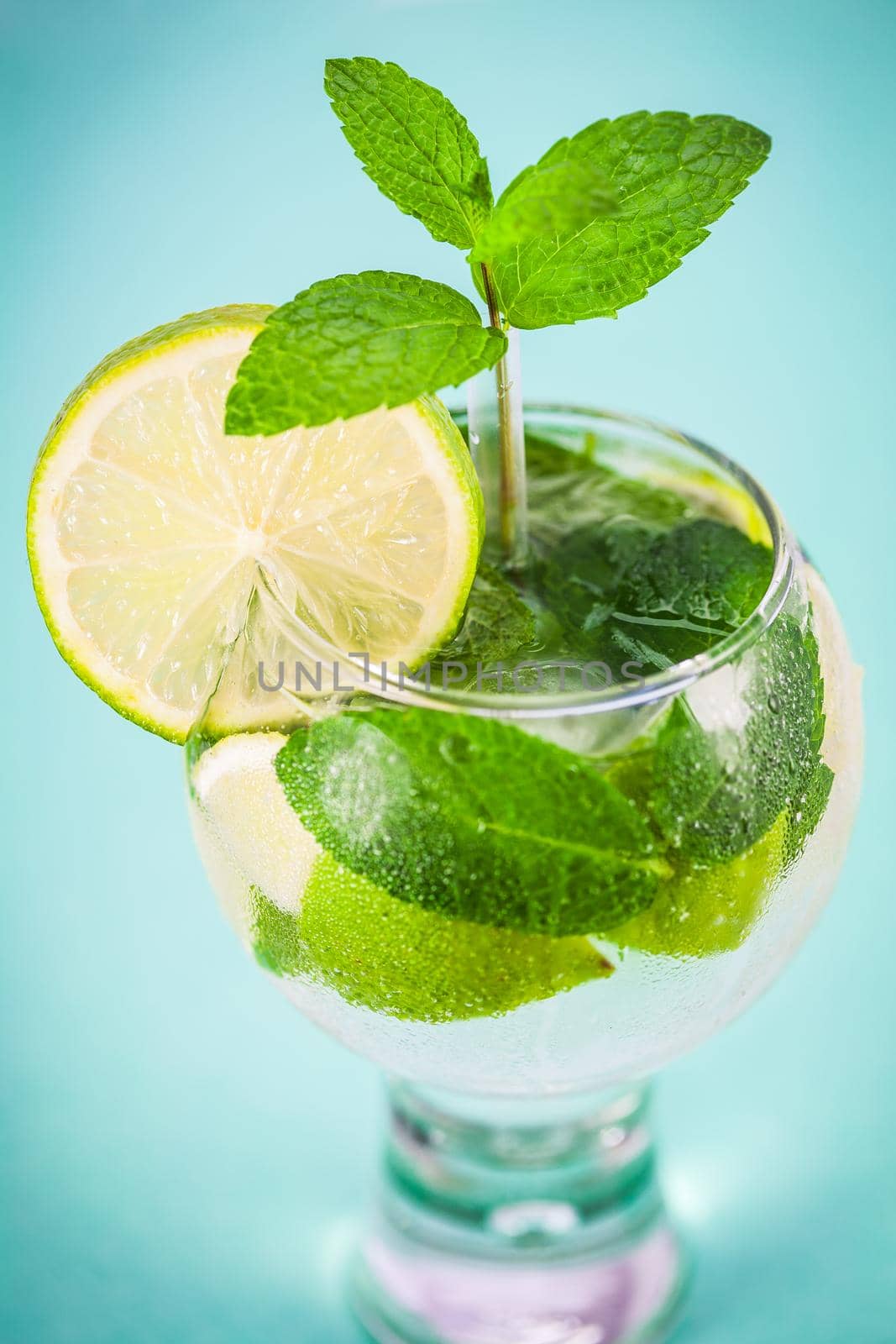 Glass of fresh mojito cocktail with ice, mint and lime