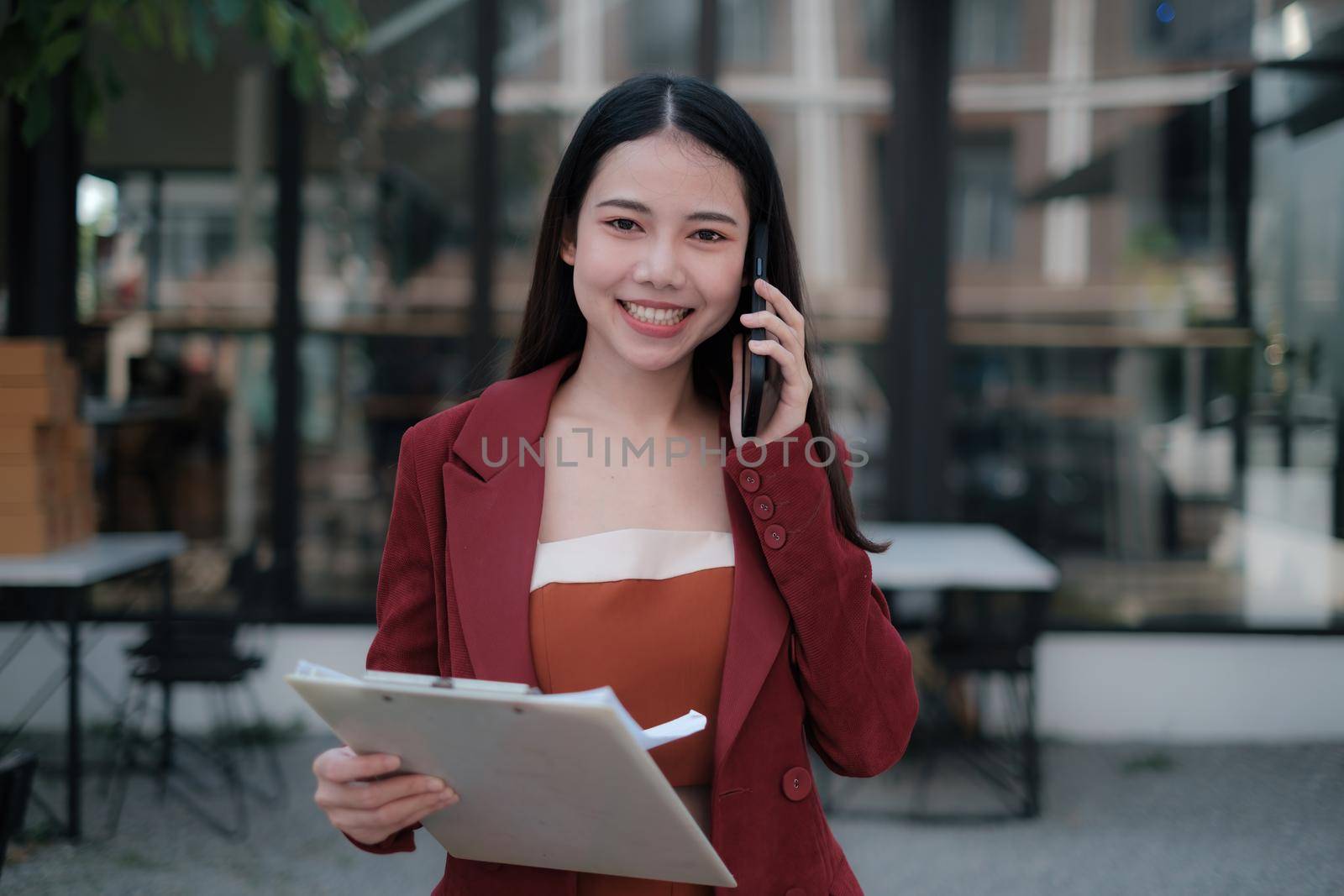 Smiling and happy asian businesswoman talking with mobile phone. Finance and Accounting concept
