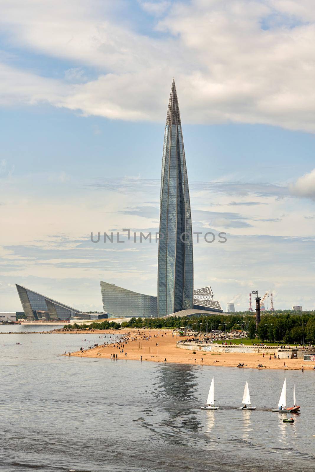 Sailing yachts sail against the background of the Lakhta Center skyscraper in St. Petersburg, Russia.