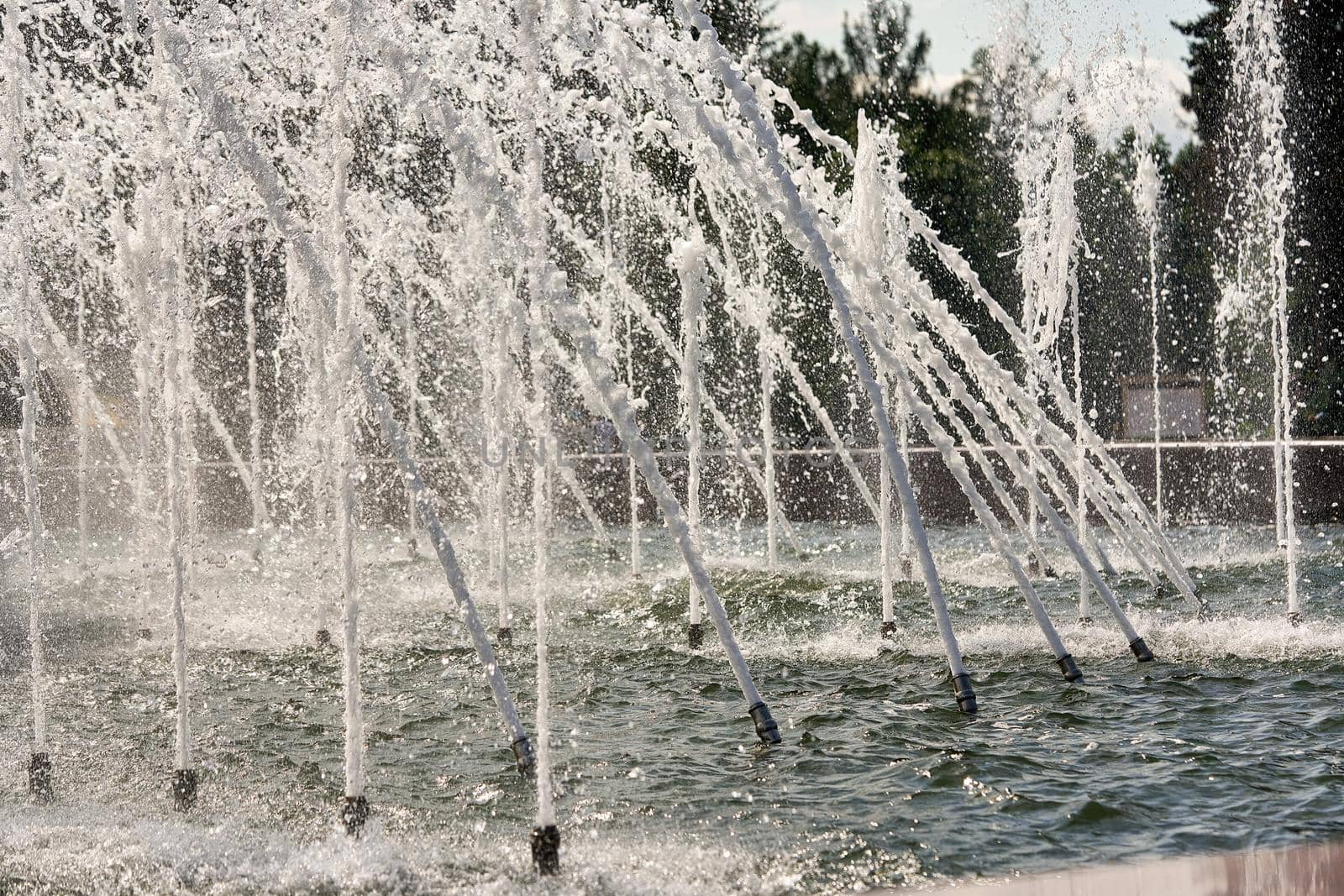 Fragment of a city fountain with water jets and splashes. Water fountain