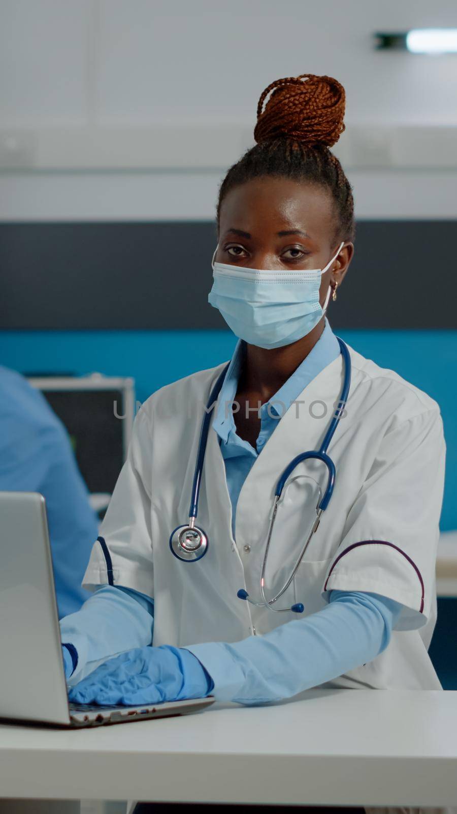 Portrait of young medic using laptop technology on desk by DCStudio