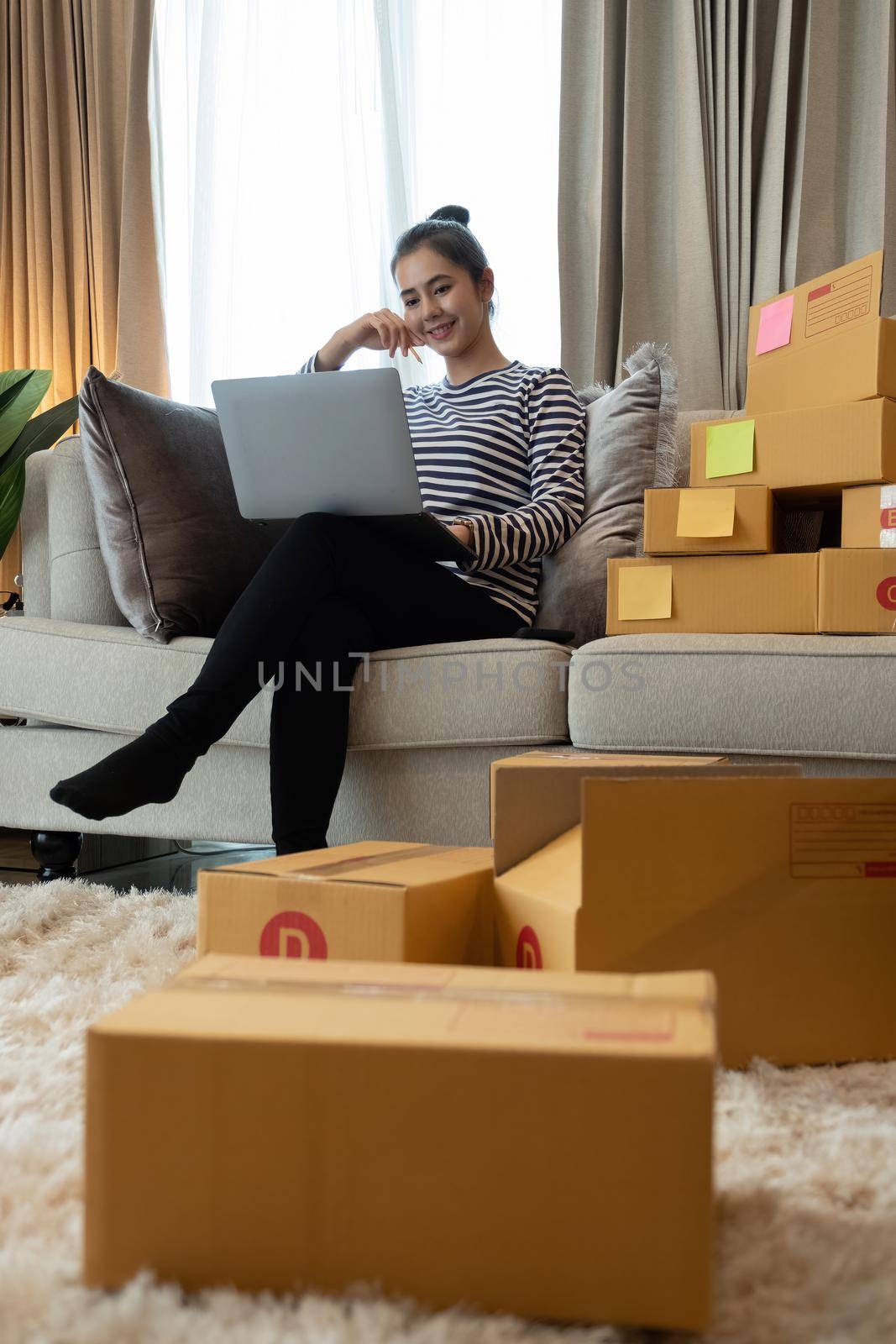 Business Start up SME concept. Young startup entrepreneur small business owner working at home, packaging and delivery situation. Women, owener of small business packing product in boxes.