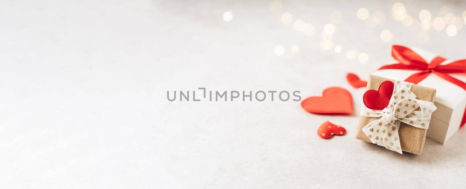 Valentine's Day banner. Gift or present box with red bow and heart shape on lights background. Copy space for text and design. Valentine day gift. Banner for Christmas, hew year, birthday concept by Ostanina