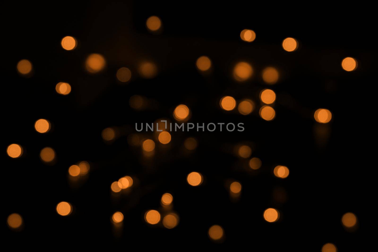Defocused bokeh lights on black background, an abstract naturally blurred backdrop by lavsketch