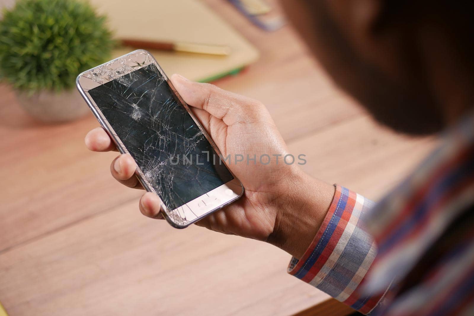 Close up of man hand holding broken smart phone