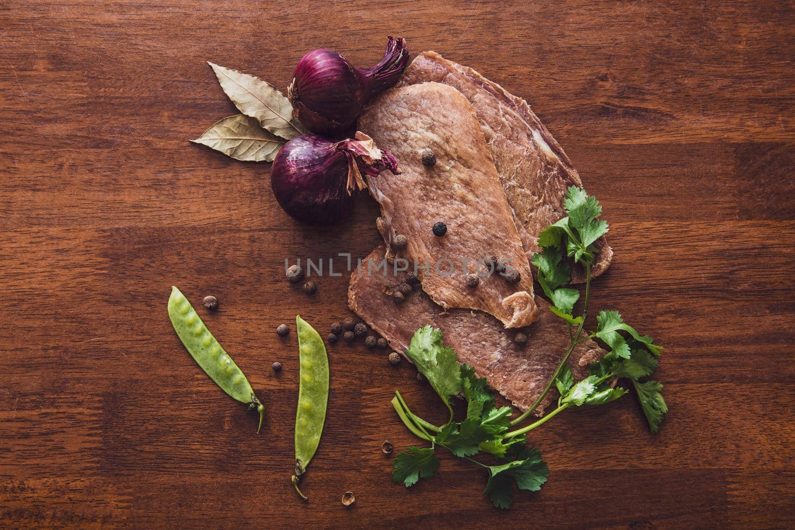 Jerky with spices, onions and herbs on an old wooden table. Beer snack top view by karpovkottt