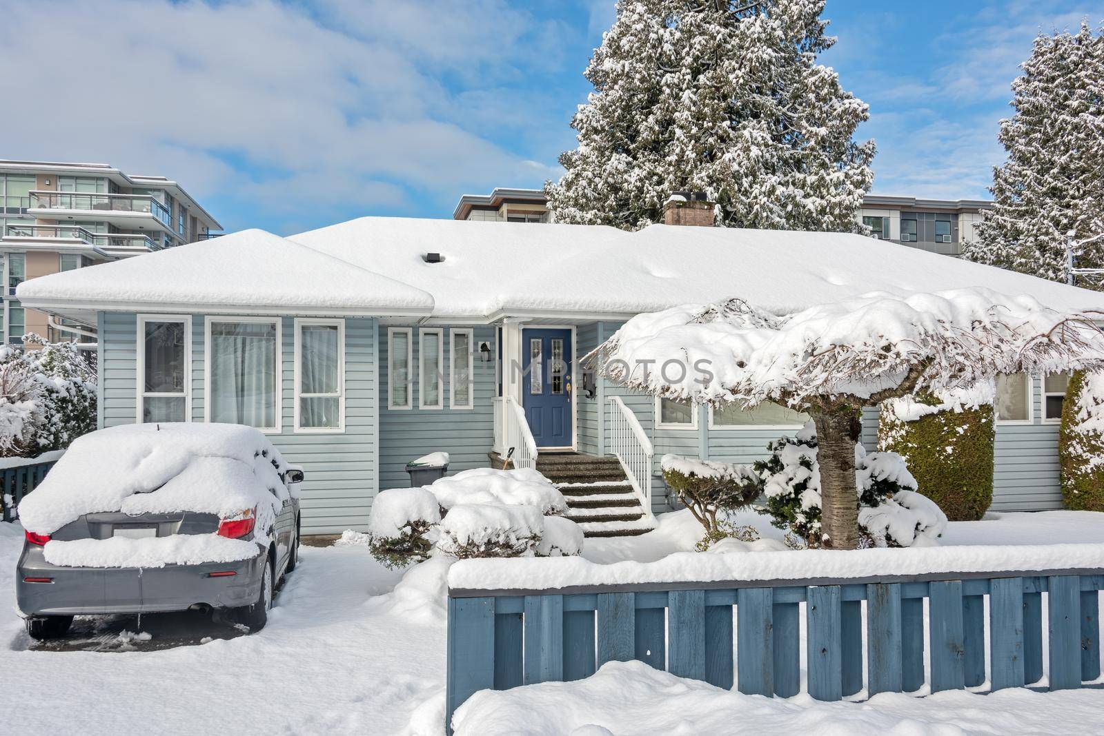 Winter street overview with residential house and apartment buildings.
