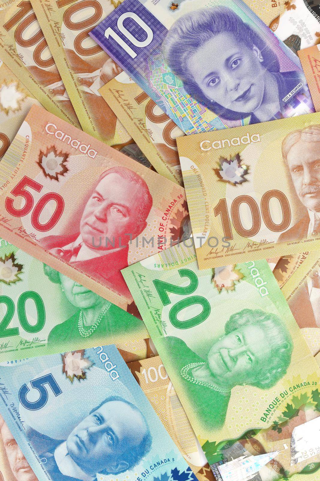 A Directly Above Full Frame Image of Canadian Banknotes of Different Values. Banknotes are piled randomly on top of each other and have values of 5 five, 10 ten, 20 twenty, 50 fifty, and 100 one hundred dollars. High quality photo