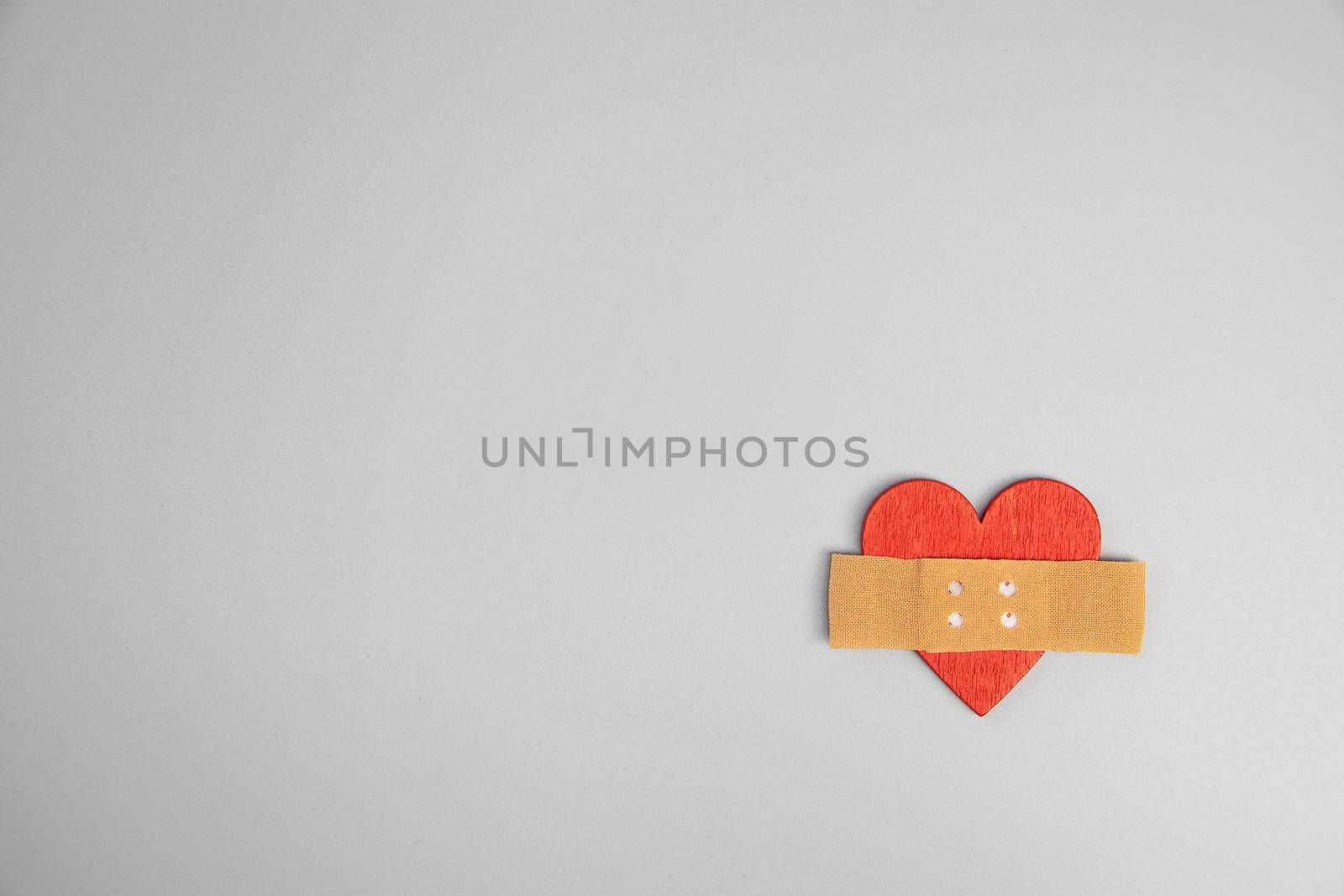 Heart with medical patch on grey background, top view. Relationship problems concept broken heart fix, Valentines Day, medical health concept cross with copy space top view space for text