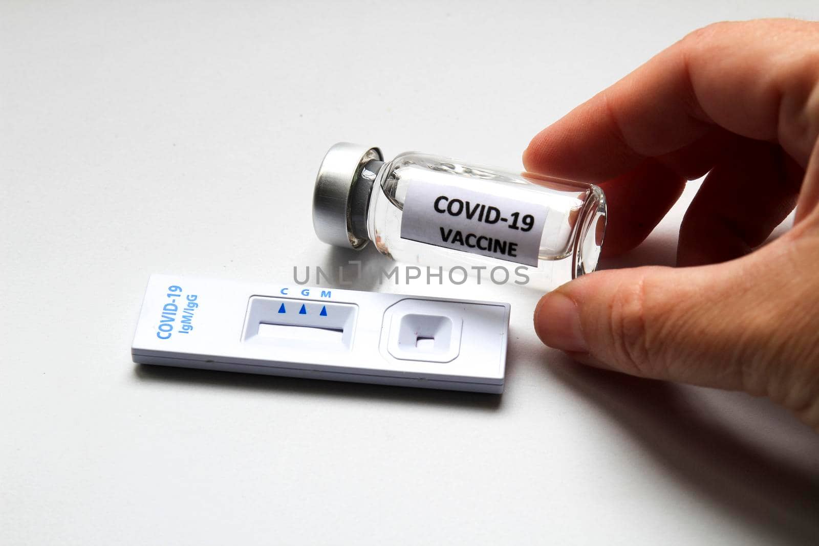 Rapid Antigen Diagnostic Test cassette of Coronavirus SARS-CoV-2 Covid-19 and vial with vaccine on white background