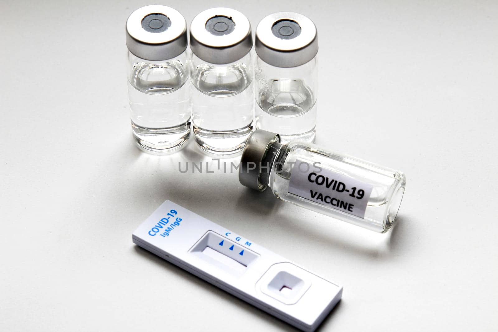 Rapid Antigen Diagnostic Test cassette of Coronavirus SARS-CoV-2 Covid-19 and vials with vaccine on white background