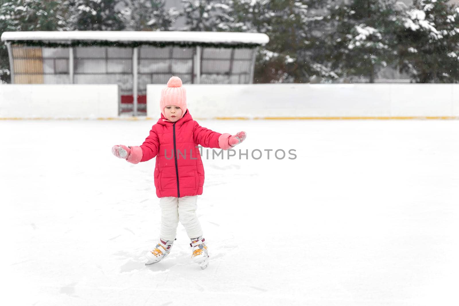 little girl ice skating on the ice rink by Lena_Ogurtsova