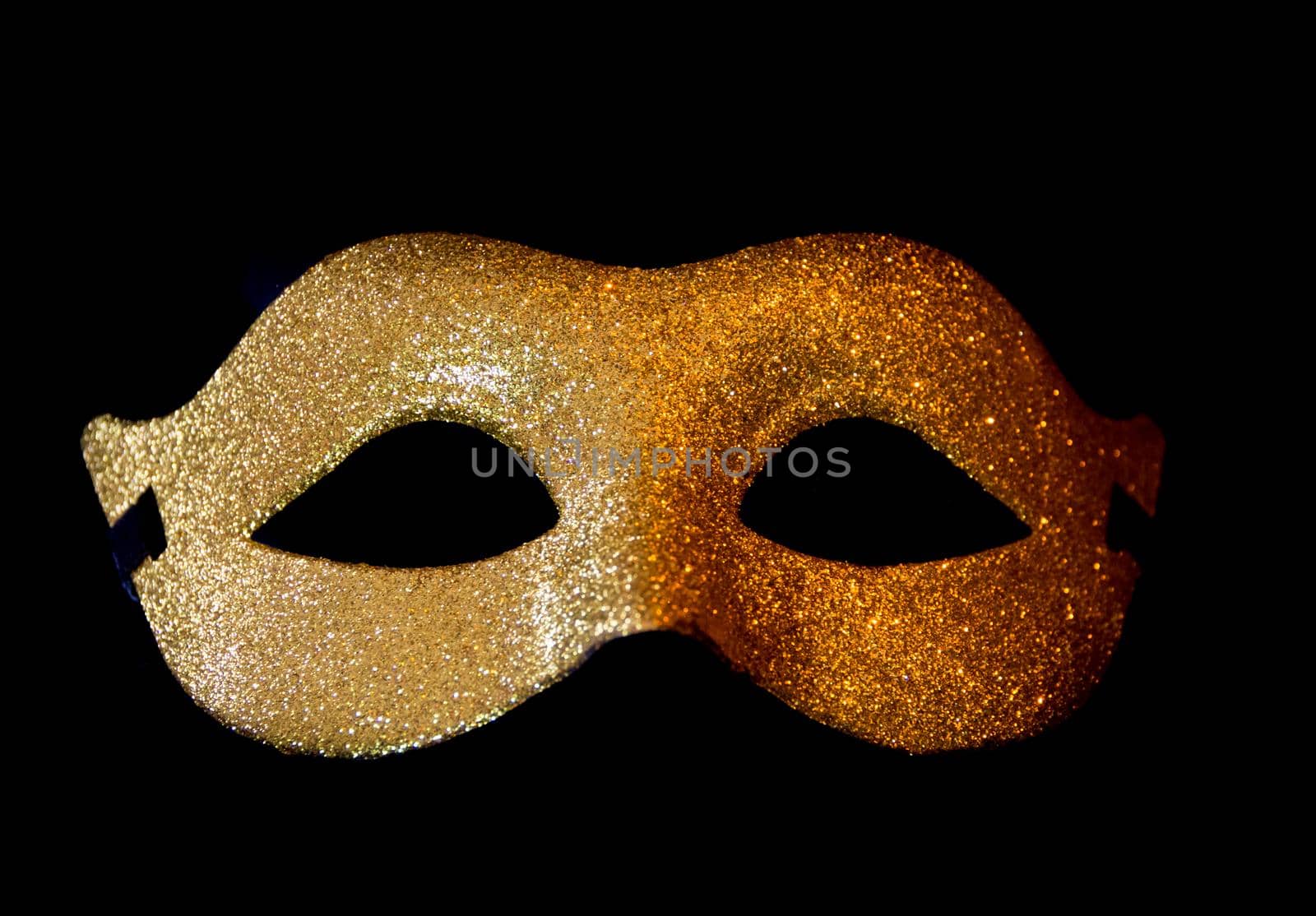 carnival symbol mask in golden color with glitter isolated on black background