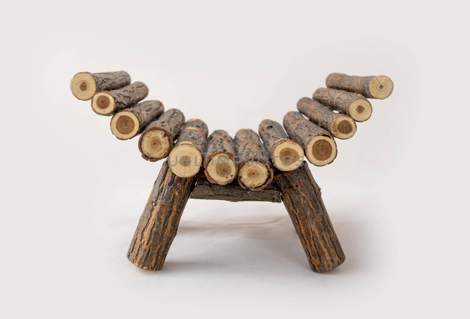 Wooden log bed for newborn baby studio photoshoot. Rural couch furniture for infant child photo session