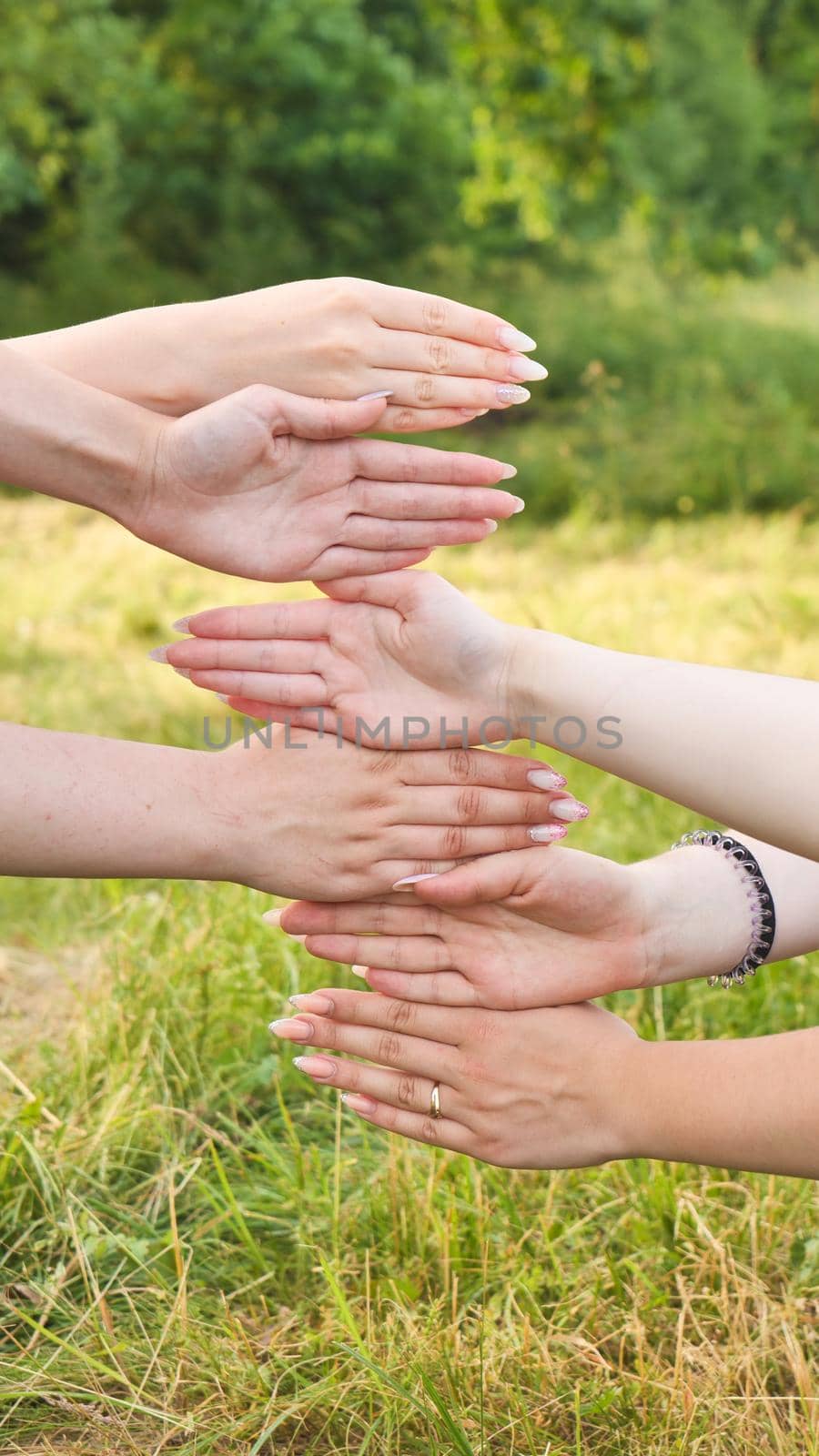 Girlfriends put their palms of their hands on top of each other