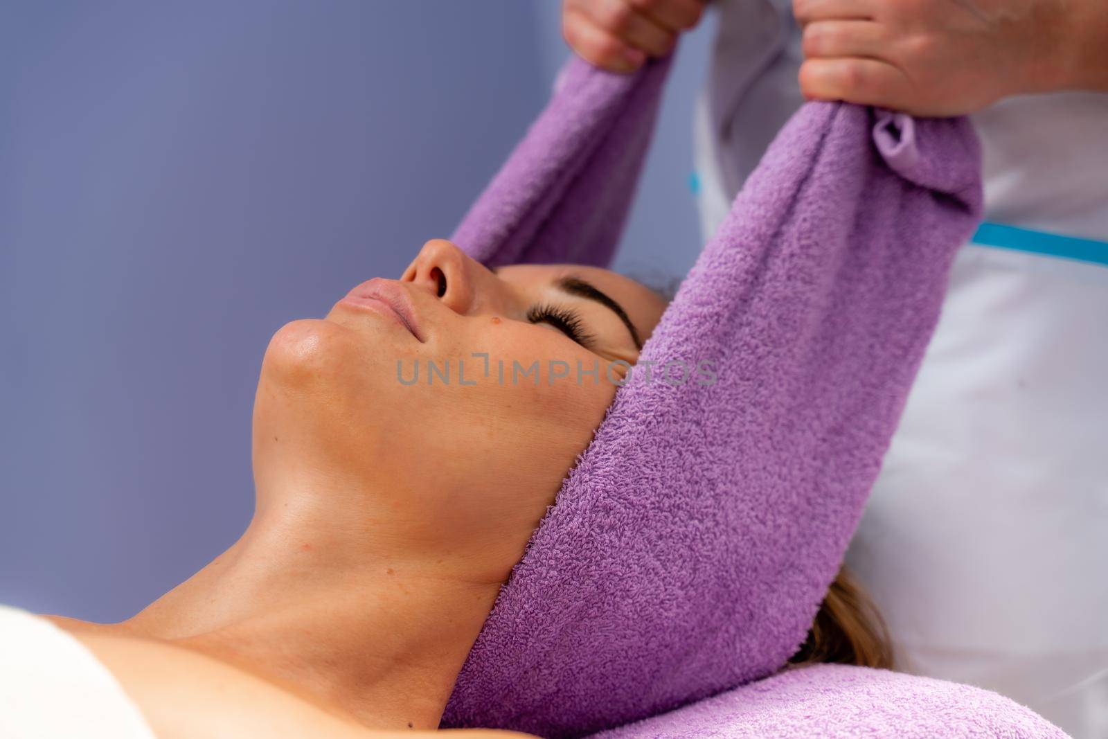 Relaxing massage. European woman getting head massage in spa salon, side view.