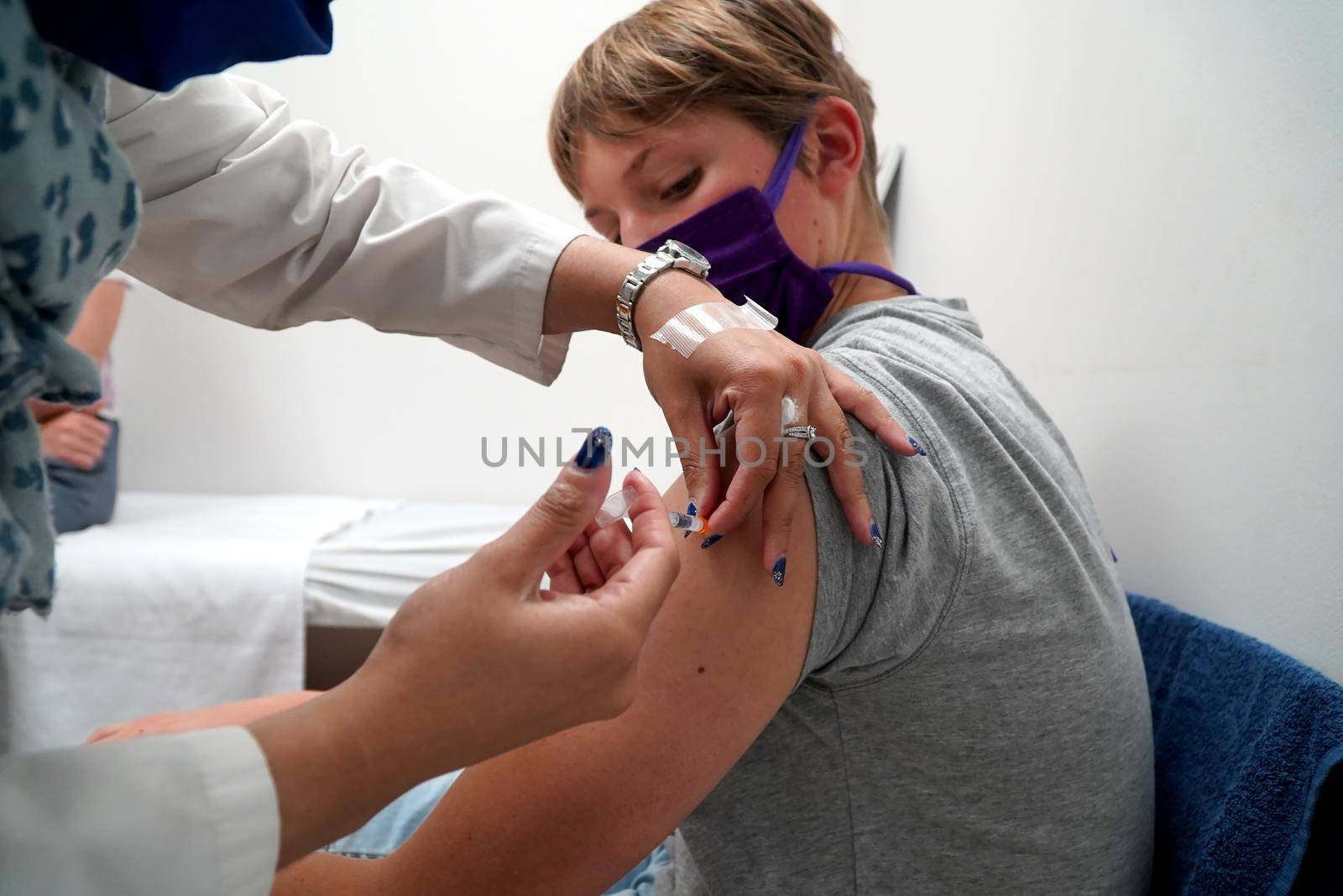 Young teenage boy getting his covid vaccination by fivepointsix