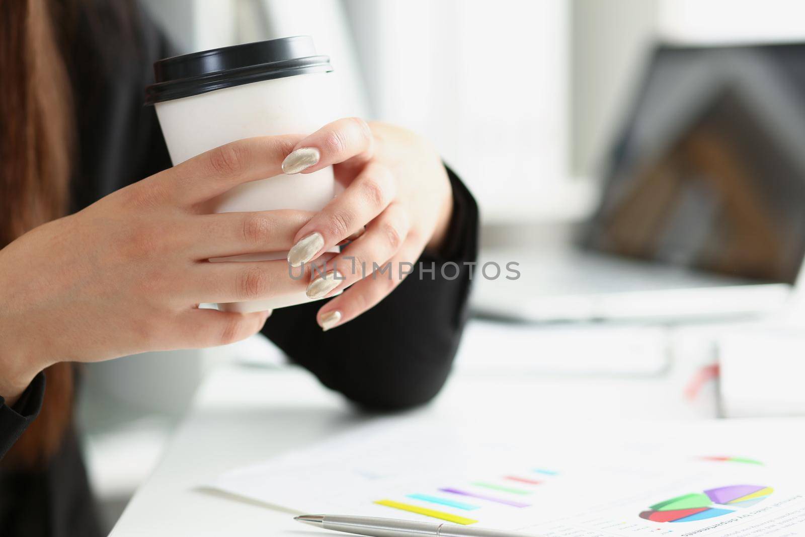 Close-up of woman with manicure hold cup of coffee, posing on working place in office. Break for lunch, enjoy drink, take pause. Chill, relaxation concept