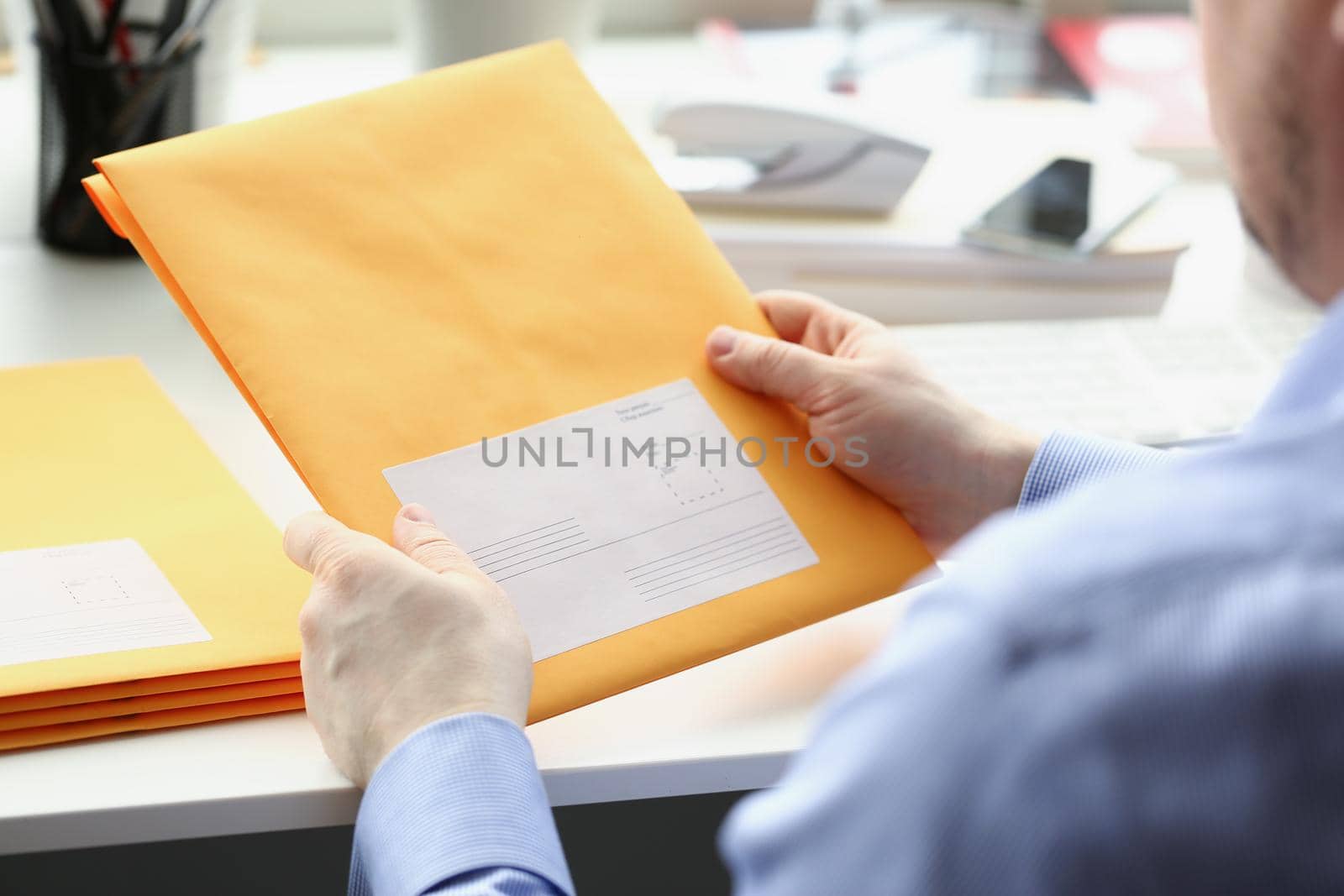 Close-up of man hold envelope, prepare package to give to courier for further delivery. Write address space on package. Delivery service, transfer concept