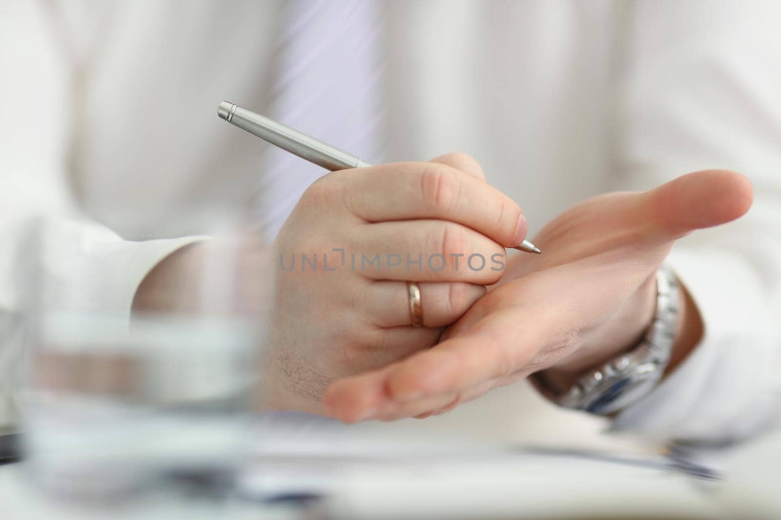 Close-up of male writing note with silver pen on his hand to keep in mind some information. Try not to forget, to do list, reminder. Note, memory concept