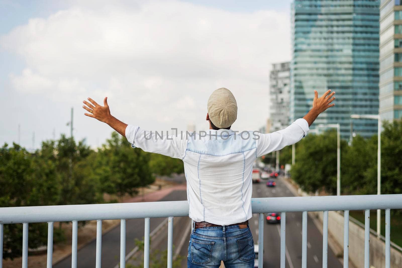 Portrait from behind of young man with arms raised outside by raferto1973