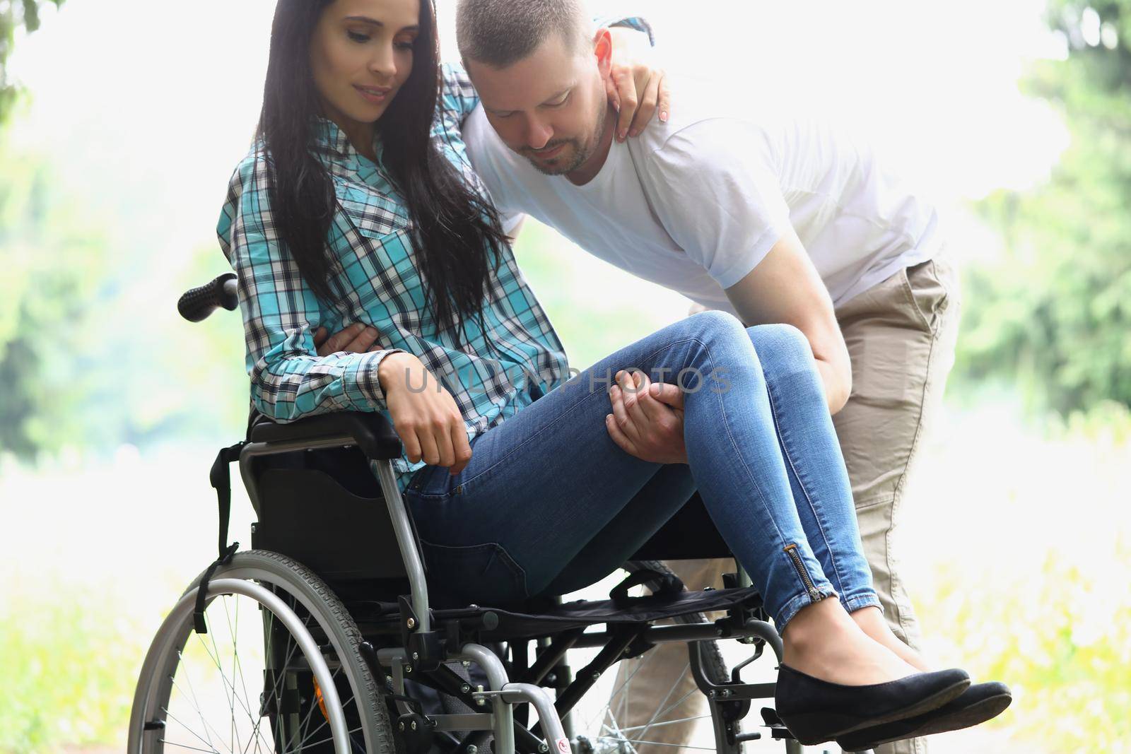 Man husband take woman in arms, disabled wife on wheelchair by kuprevich