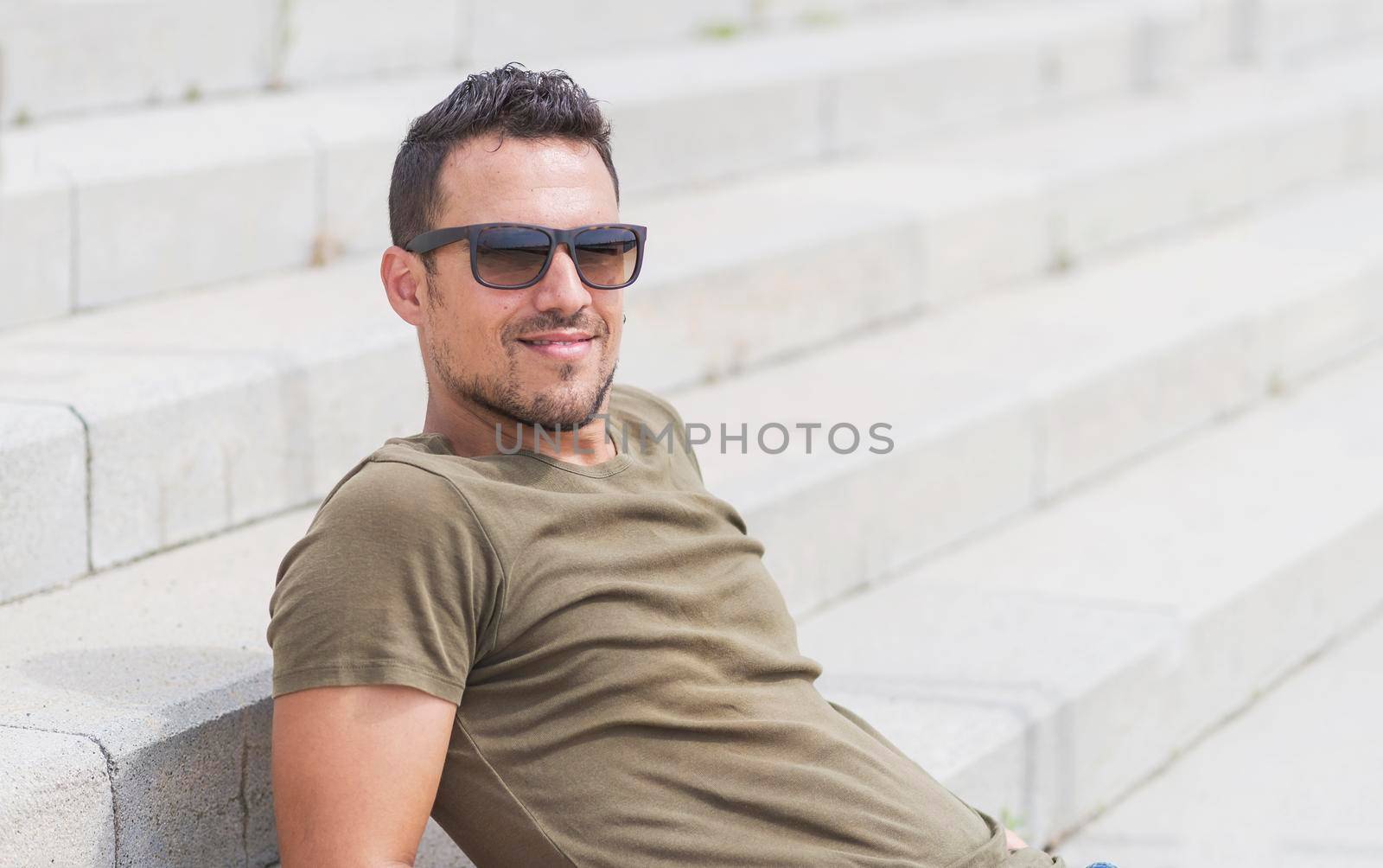 Man sitting alone on steps. Handsome boy with sunglasses by raferto1973