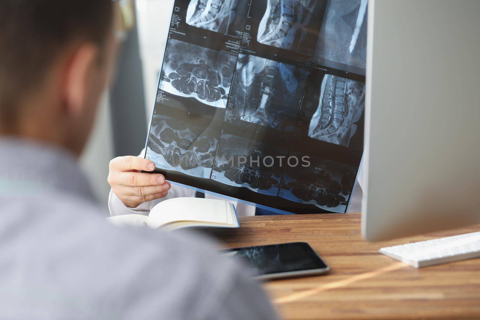 Close-up of doctor examining patients xray result in hospital on appointment with client. Scan of persons back. Healthcare, medicine, diagnostic concept