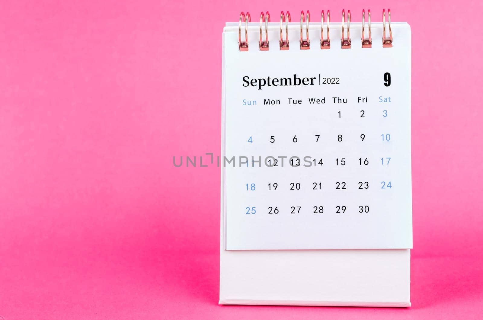 The September 2022 desk calendar on pink background.