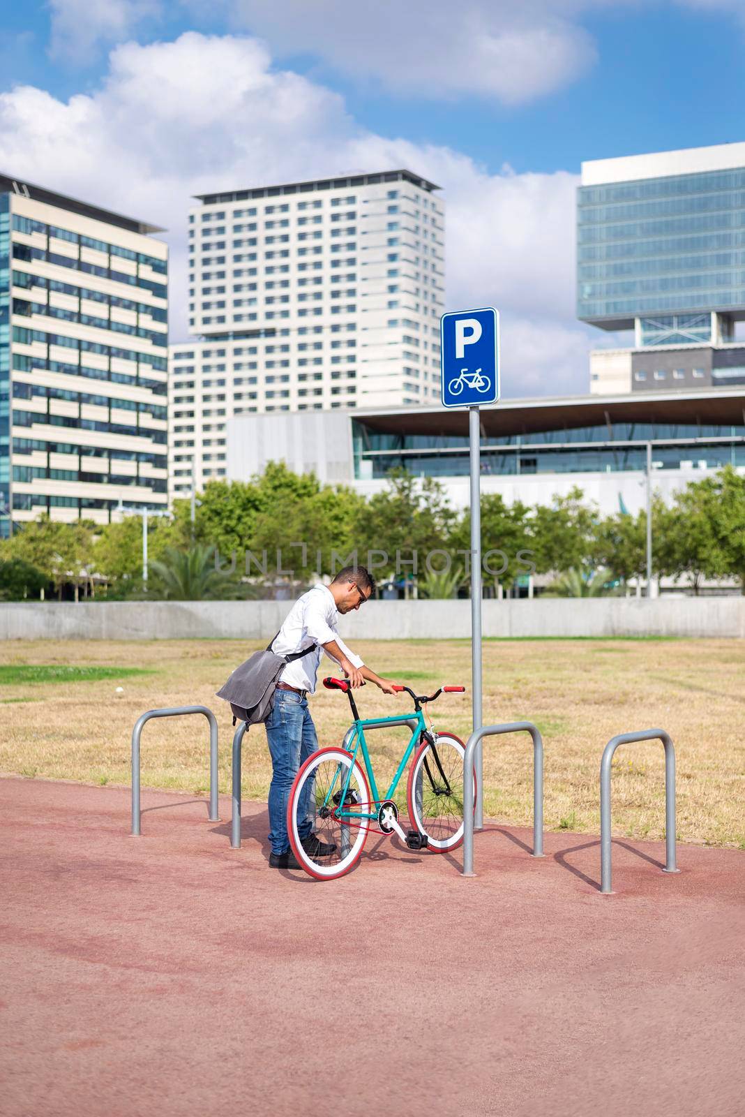 business, lifestyle, transport and people concept - young man parking bicycle on city street