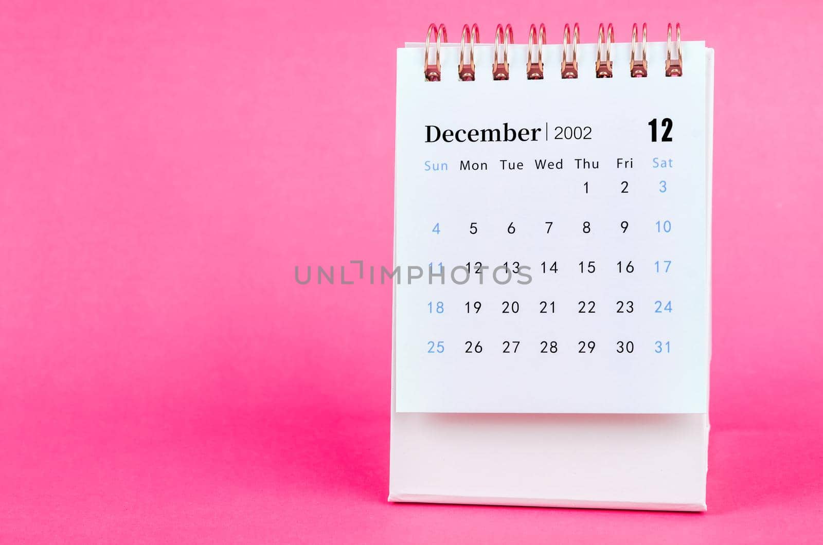 The December 2022 desk calendar on pink background.