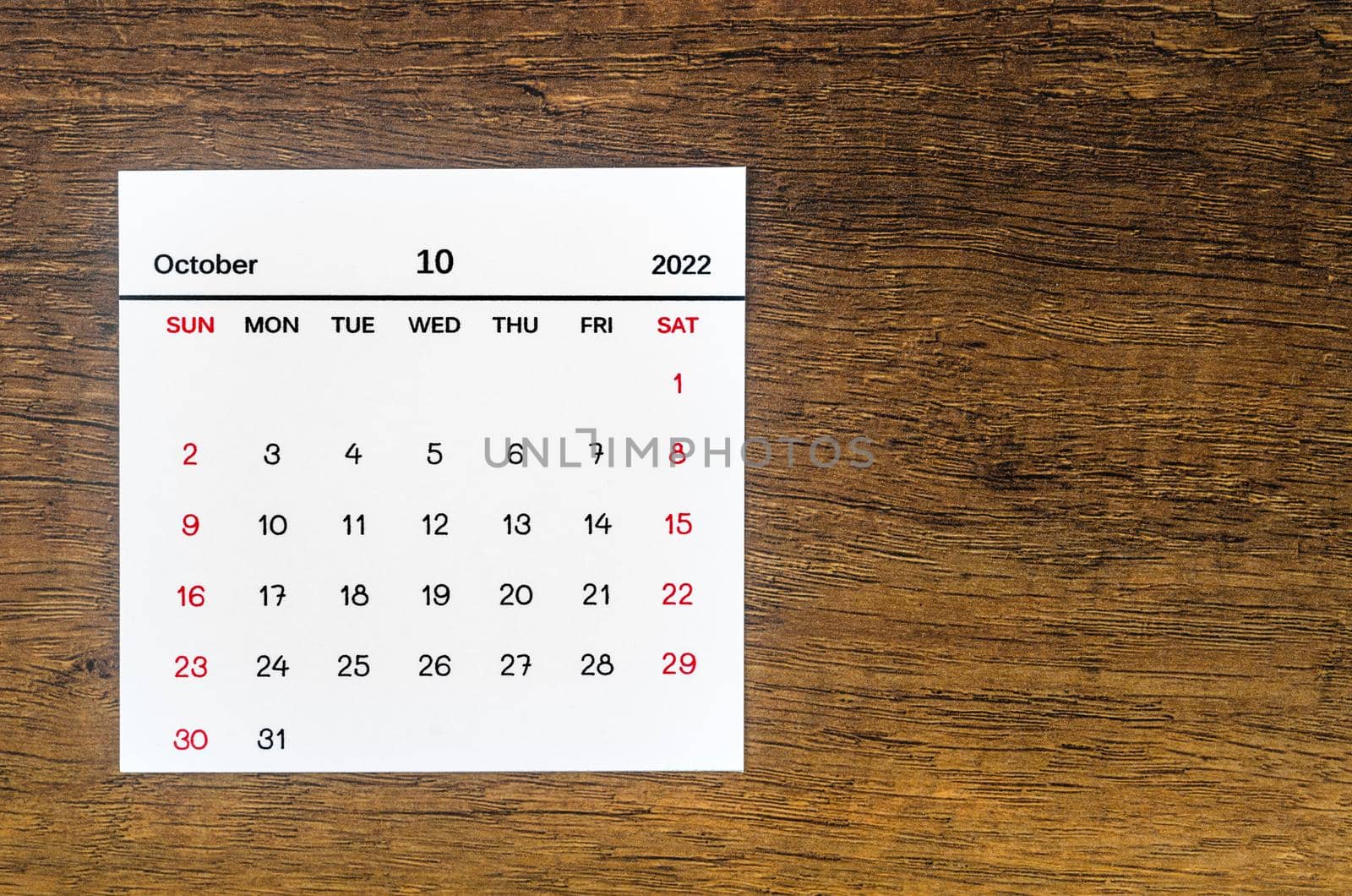 The October 2022 calendar on vintage wooden background.