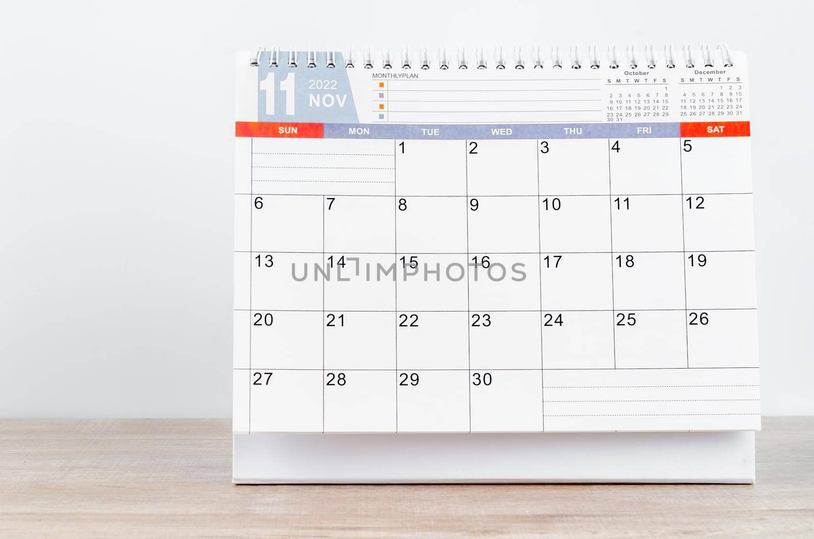 The November 2022 desk calendar on wooden table.
