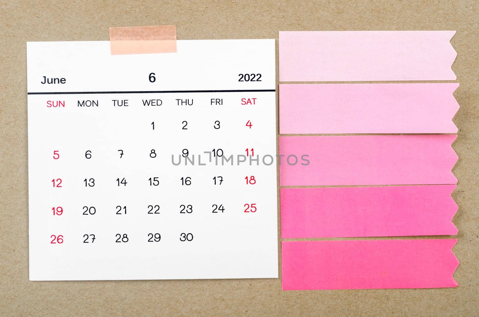June 2022 calendar with blank adhesive note paper on brown background.