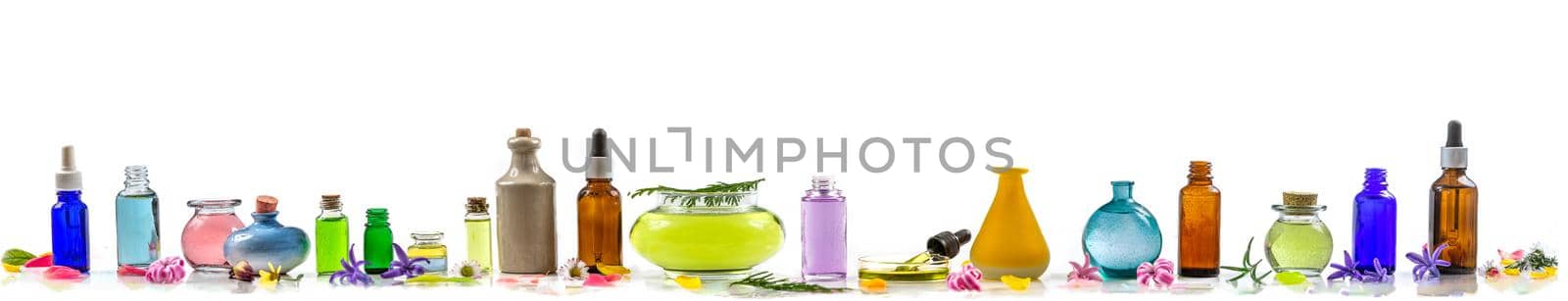 Panel of essential oils in various bottles aligned on a panoramic white background