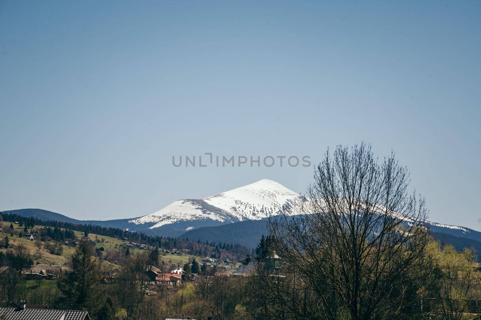 Snow-capped mountain on the horizon, and mountain villages by Dmytro125