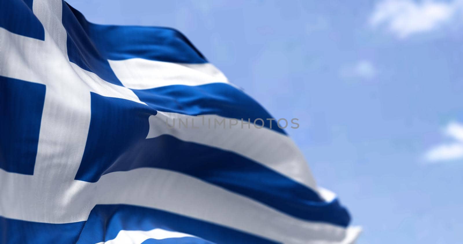 Detail of the national flag of Greece waving in the wind on a clear day by rarrarorro
